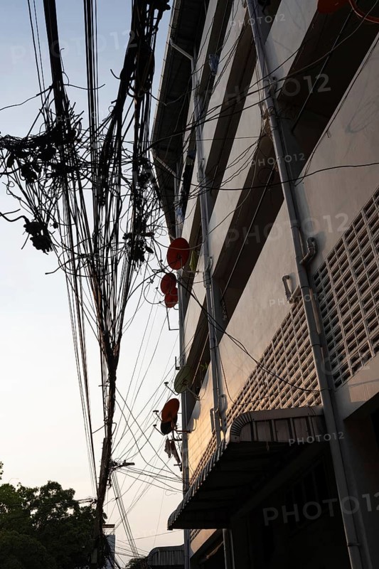 Bangkok, Thailand. March 4th 2025. A tangled mess of cables and wires used for phone and internet connections hanging from a pole in the street in central Bangkok, Thailand