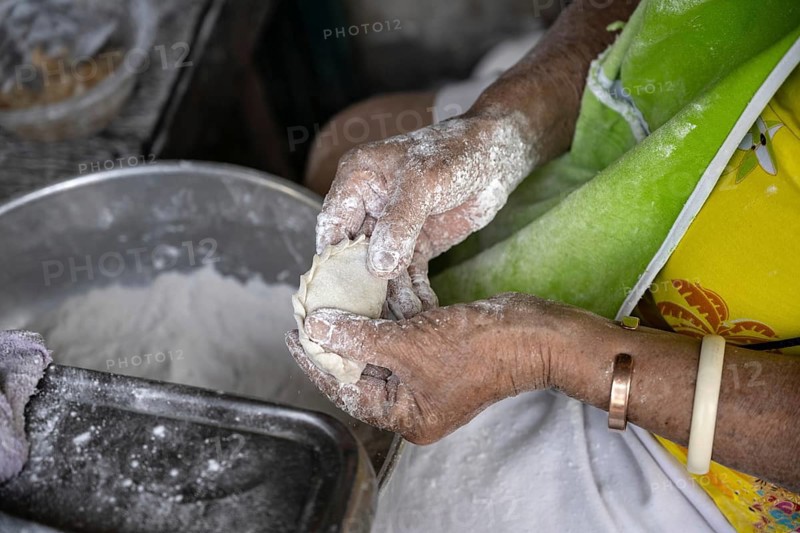 A Thai women preparing traditional pastry to be baked and sold in a Bangkok street market, Thailand