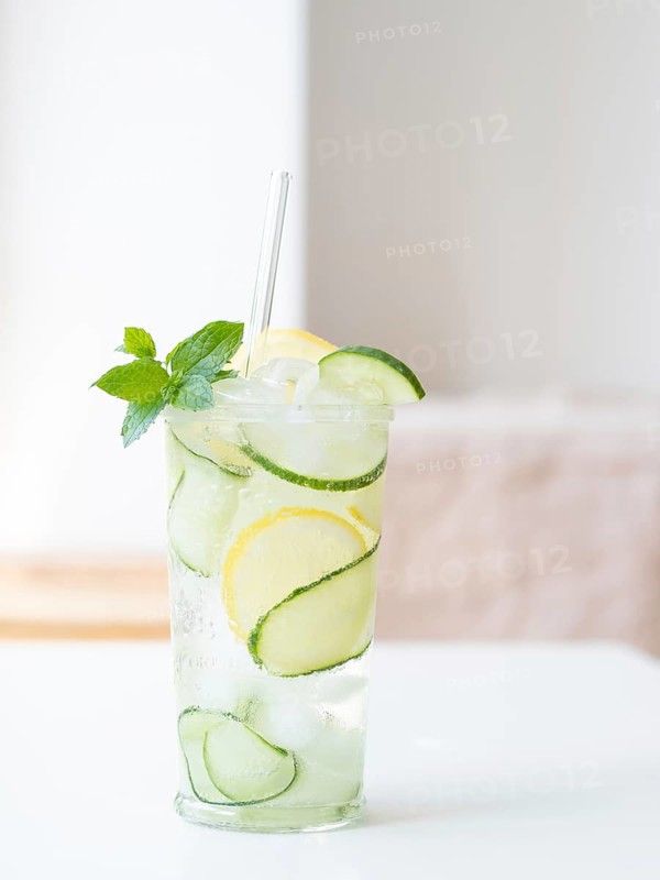 Cucumber detox water with lemon, mint, ice, and a straw offering a healthy refreshment