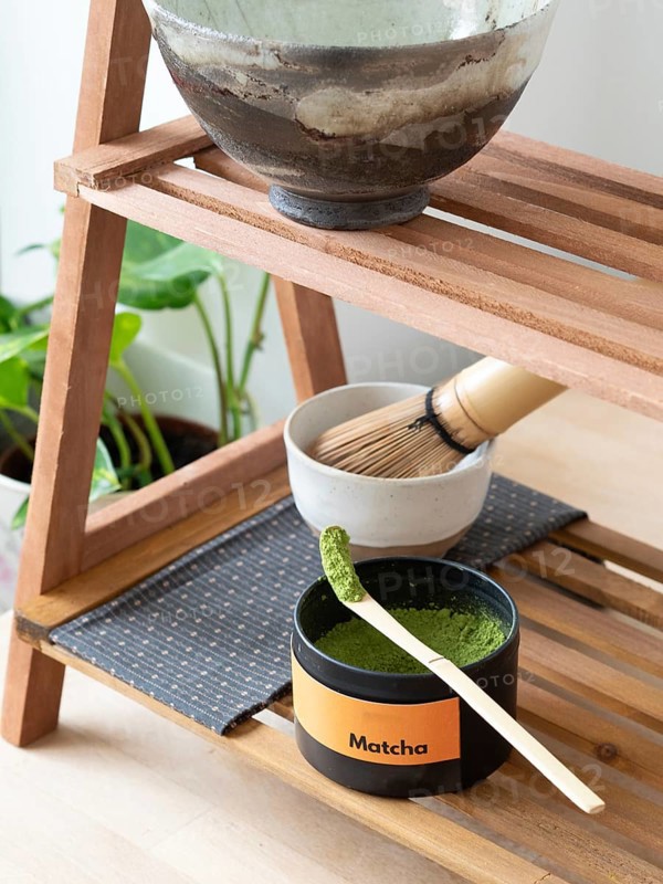 Matcha powder in a scoop with whisk and bowl ready for a traditional tea ceremony
