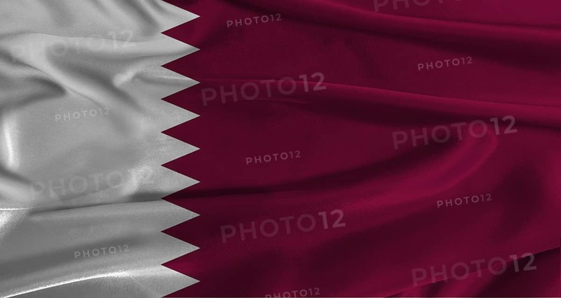 Flag of Qatar with fabric textured background. Close up of National flag of Qatar with realistic texture