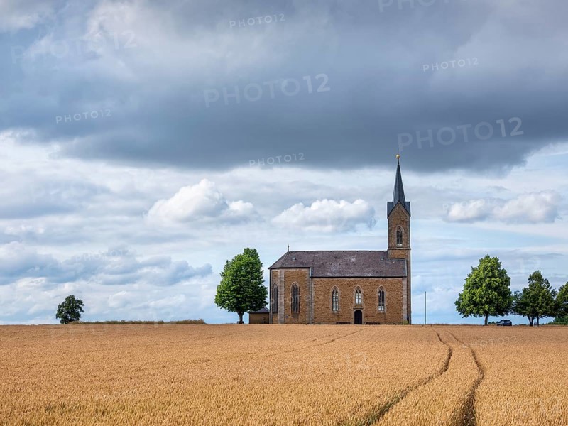 View over a wheat field to the Bischwinder chapel Maria Hilfe der Christenheit, Bischwind, Lower Franconia, Bavaria, Germany