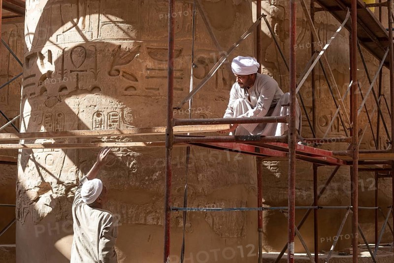 Luxor, Egypt. December 12th 2022 Local Egyptian workers cleaning and restoring the ancient columns of Karnak Temple near the River Nile, Luxor, Upper Egypt
