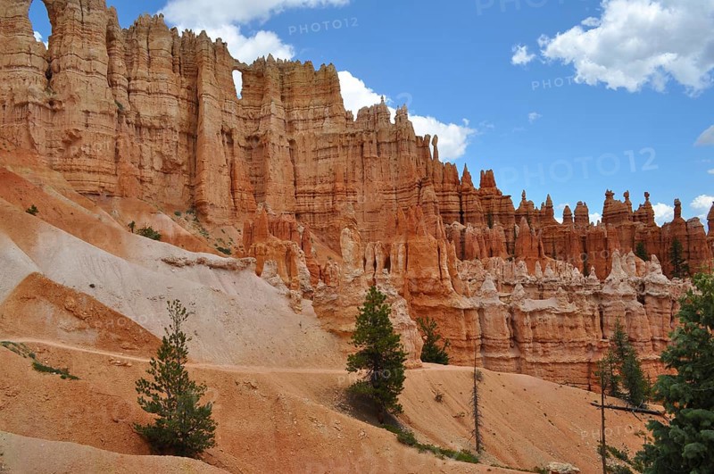 Hiking trail leads past bizarre red rock needles and pine trees in Bryce Canyon National Park, Utah, USA
