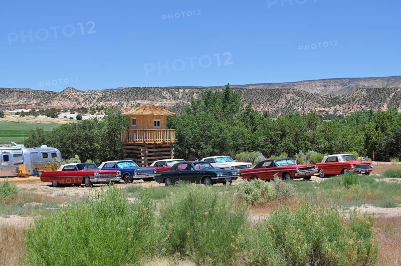 Several classic American cars park side by side in a meadow with a hilly landscape in the background, Shooting Star Drive In Airstream Resort, Bryce Canyon National Park, Utah, USA