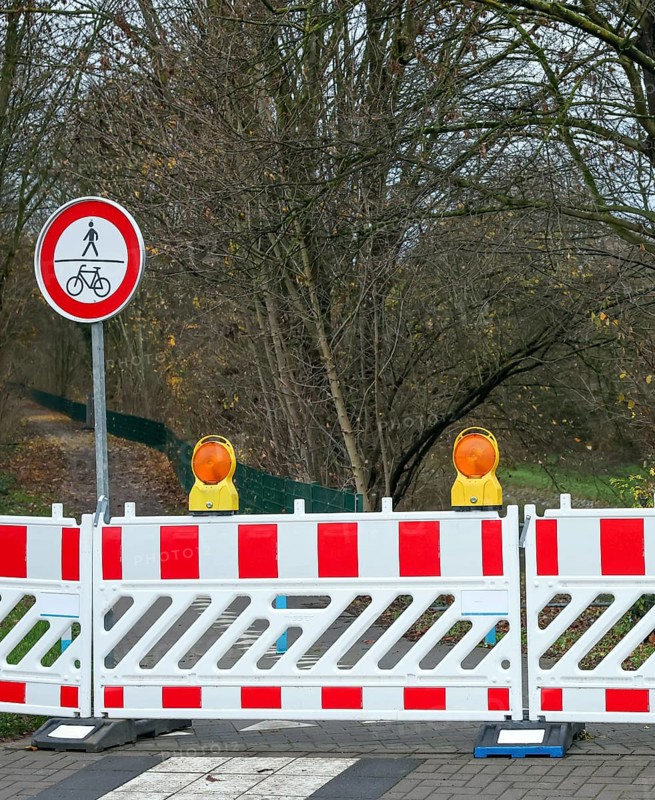 Castrop-Rauxel, North Rhine-Westphalia, Germany - A bicycle path, footpath is blocked off by signs, barrier fence, warning beacons, here due to a probe of war