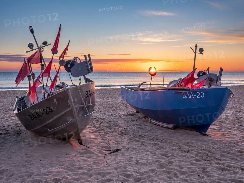 Fishing boats with red flags on fishing beach on the Baltic Sea at sunrise, Baabe, Mönchgut peninsula, Rügen island, Mecklenburg-Western Pomerania, Germany
