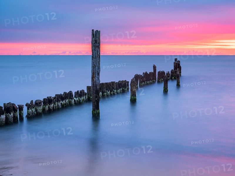 Sunrise on the Baltic Sea beach with old grouse at the Baltic Sea resort of Breege-Juliusruh, Wittow Peninsula, Rügen Island, Mecklenburg-Western Pomerania, Germany