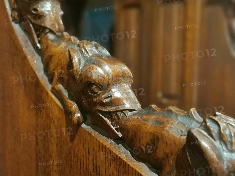 Wood carving of a dragon (draconis) biting the tail of the dragon in front of it in a detailed depiction, Poland