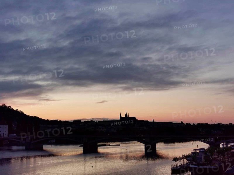 Pink sunset over the Vltava with silhouettes of Charles Bridge and Hradcany, Prague, Czech Republic