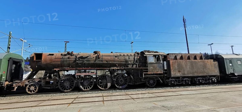 Transfer of a rusted historic steam locomotive on rails under clear blue skies at the train station, Rennsteig, Frankenwald nature park Park