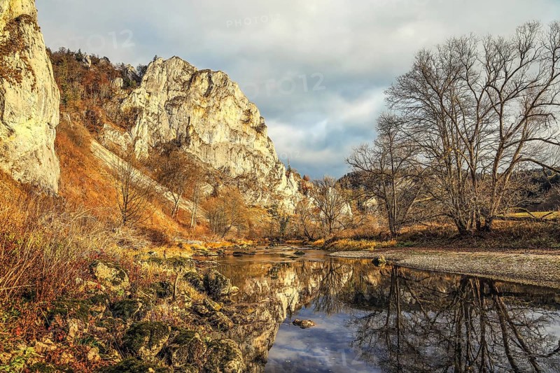 An autumn landscape with a river reflecting the surrounding rocks and trees, under a cloudy sky, Upper Danube nature park Park, Fridingen, Tuttlingen district, Baden-Württemberg, Germany