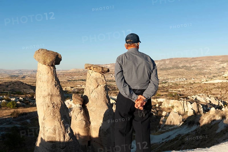 Urgup, Cappadocia, Turkey. September 18th 2018 A Turkish man enjoys the beautiful view of the Three Graces fairy chimneys, an iconic rock formation, part of Cappadocia national park in Central Turkey