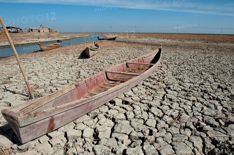 A traditional Marsh Arab canoe known as a Mashoof is left abandoned on the dry cracked earth of the southern marshes of Iraq during a hash summer drought. Climate change and political instability a potential risk to sustainability in the wetlands