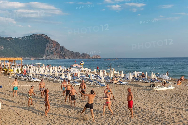 Holiday makers playing volleyball on Cleopatra Beach in the Turkish holiday resort town of Alanya on the Mediterranean coast of Turkey, the Turkish Riviera