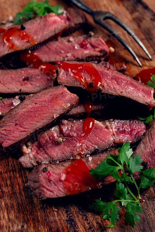 Fried steak, beef steak, rib eye steak, sliced steak, on a chopping board, top view, no people