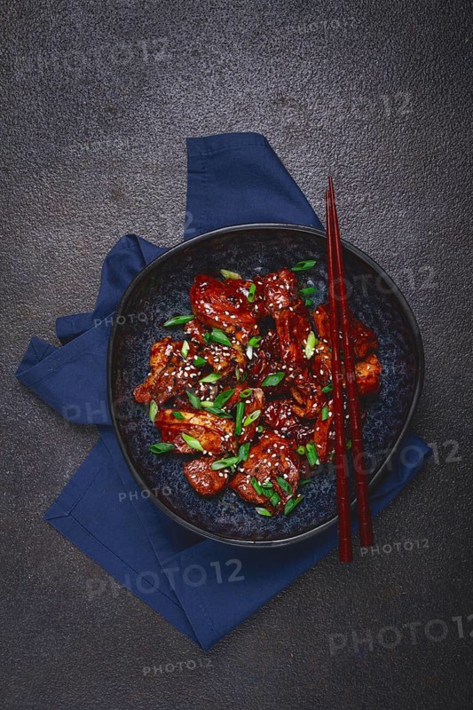 Yakitori chicken kebab, on a plate, with green onions and sesame seeds, top view, no people