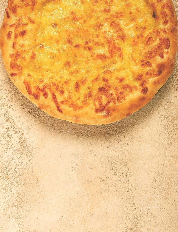 Khachapuri in Megrelian, a traditional Georgian dish, flatbread with cheese, top view, no people