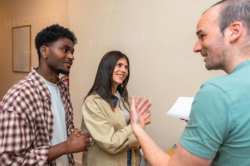 Diverse indoor group smiling, talking and listening during a casual meeting or workshop, exchanging ideas and building collaboration, networking and friendly teamwork