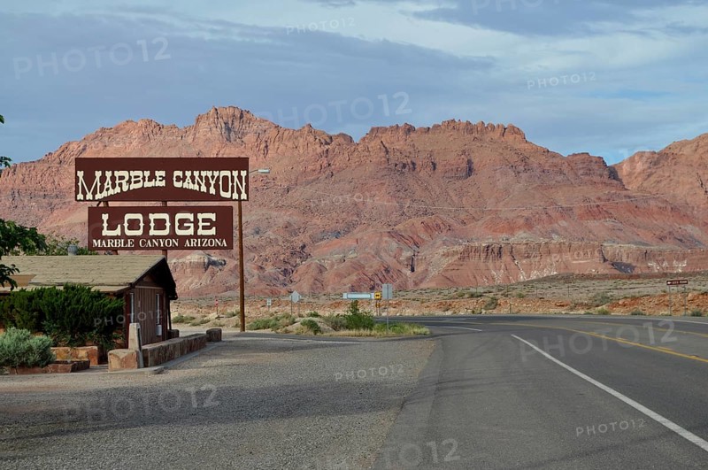 Lodge on a road in the desert in front of a rocky landscape with clouds in the sky, Grand Canyon National Park, Arizona, USA