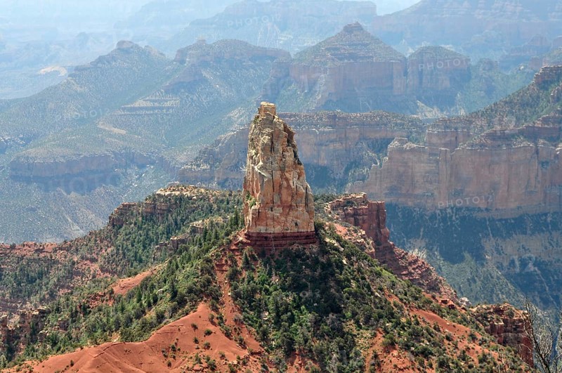 A distinctive rock formation rises in the midst of a rough and dry canyon landscape with wide views, Grand Canyon National Park, Arizona, USA