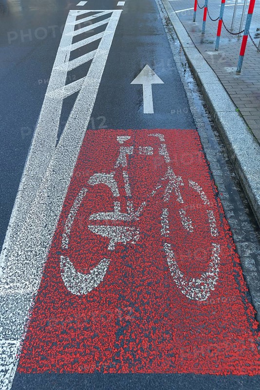 Red marked bicycle path on the road, Krakow, Poland
