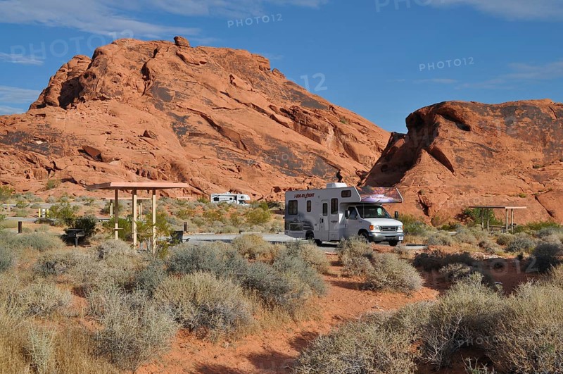 RV on campground in desert landscape with large red rocks and sparse vegetation, Valley of Fire State Park, Nevada, USA