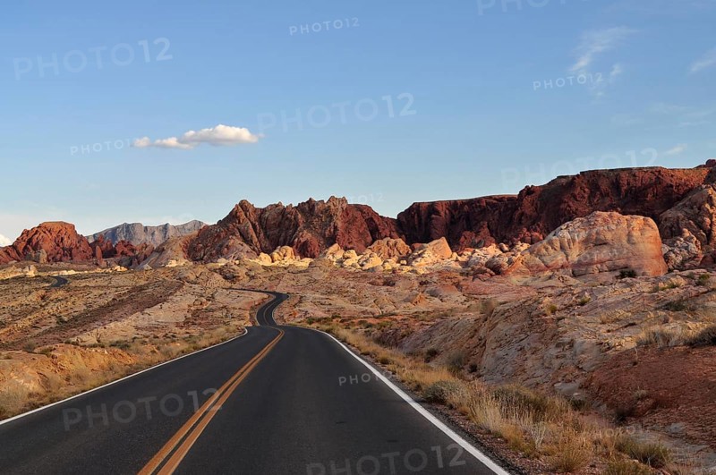Small, winding road leads through red rocky landscape in the desert at sunset, Valley of Fire State Park, Nevada, USA