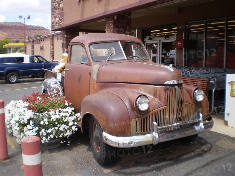Nostalgic, rusty Studebaker pick-up truck with flower decoration in front of the Honey's Marketplace store, Zion National Park, Utah, USA