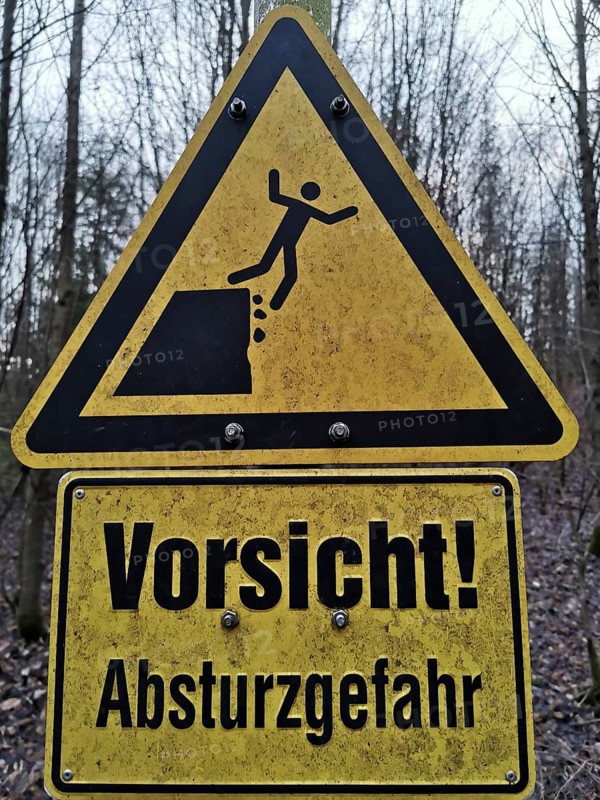Yellow warning sign in the forest with an indication of the risk of falling, quarry, Frankenwald nature park Park
