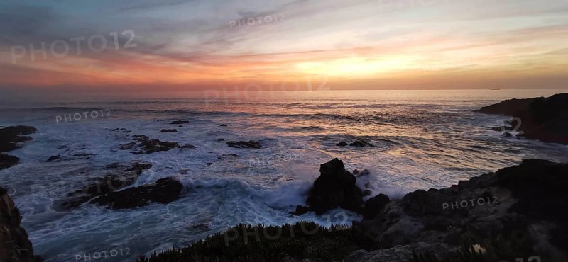 Sunset over the sea, gentle waves and rocks in a tranquil atmosphere, hiking on the Fisherman's Trail, Southwest Alentejo nature park Park and Vicentina Coast, Portugal