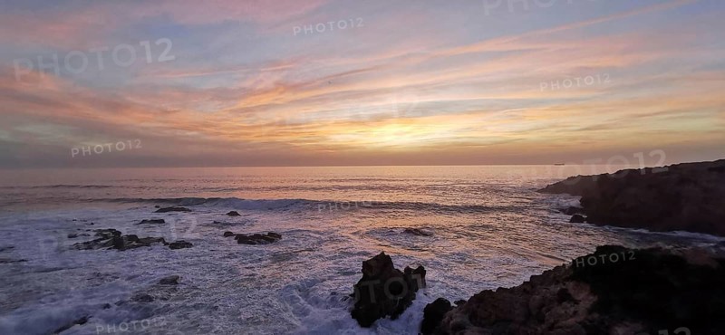 Pastel-coloured sunset over the sea. The light of the sky is reflected gently over the waves, hiking on the Fisherman's Trail, Southwest Alentejo nature park Park and Vicentina Coast, Portugal
