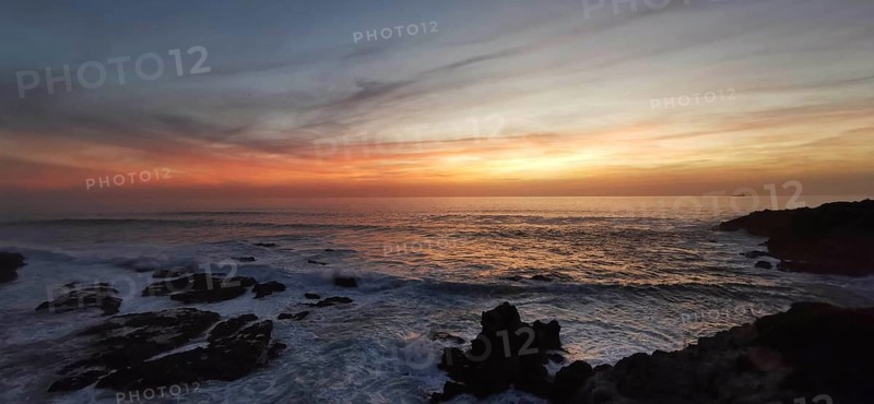 Calm sunset over the sea, soft colors in the sky and views of rocks, hiking on the Fisherman's Trail, Southwest Alentejo nature park Park and Vicentina Coast, Portugal