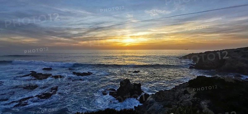 A breathtaking sunset over the sea with dramatic waves and rocks, hiking the Fisherman's Trail, hiking the Fisherman's Trail, Southwest Alentejo nature park Park and Vicentina Coast, Portugal