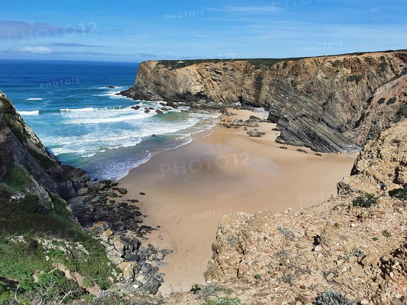 Secluded bay with golden sandy beaches and breaking waves between steep cliffs, hiking on the Fisherman's Trail, Algarve, Portugal