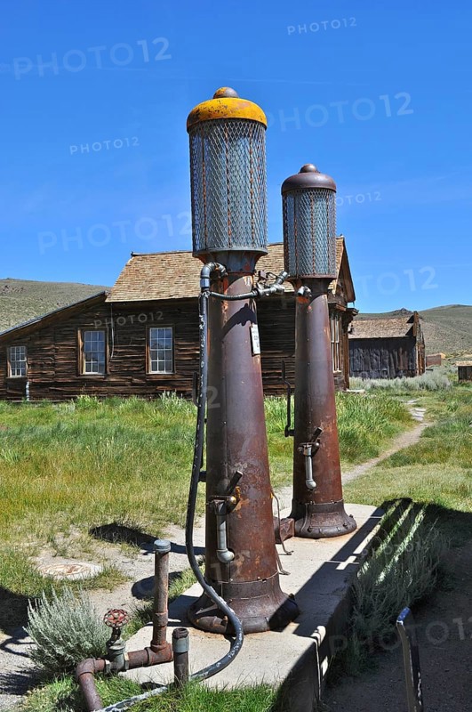 Two rusty old gas pumps, gas station, in front of a historic wooden building under a blue sky, Bodie Ghost Town, California, USA