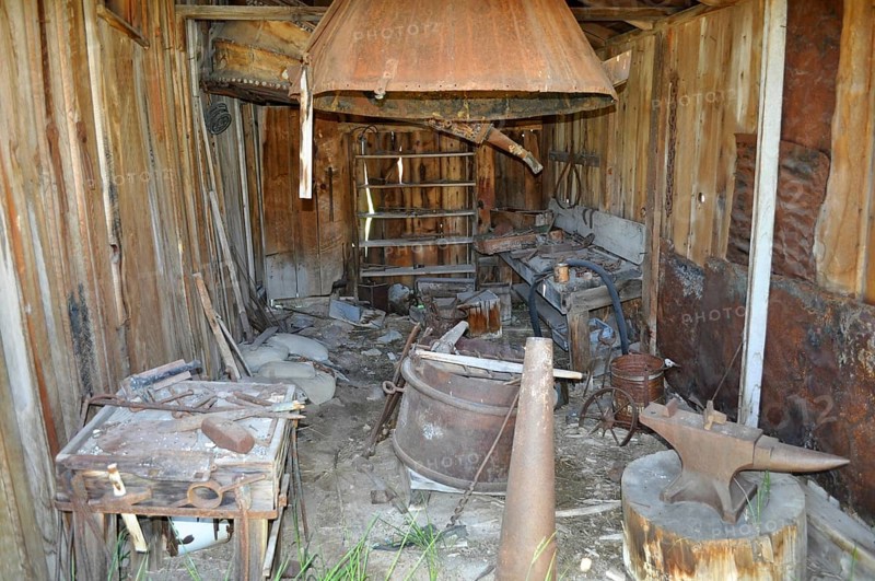 An old blacksmith workshop with rusty tools and wooden structures in an abandoned state, Bodie Ghost Town, California, USA
