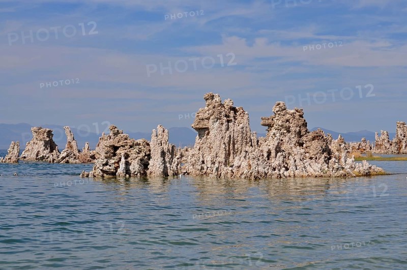 Unique rock structures, limestone formations rising from the calm water of a lake under a clear sky, Lake Natron, Mono Lake, California, USA