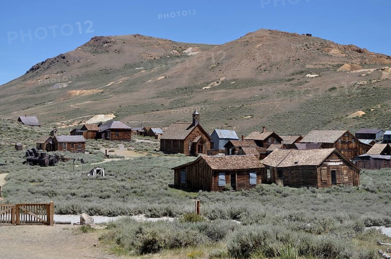 Abandoned wooden houses in a ghost town with desert landscape in the background, Bodie Ghost Town, California, USA