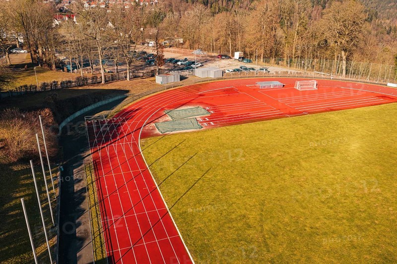Sports field with red track and shade, surrounded by trees and green space, Wimberg, Calw, Germany