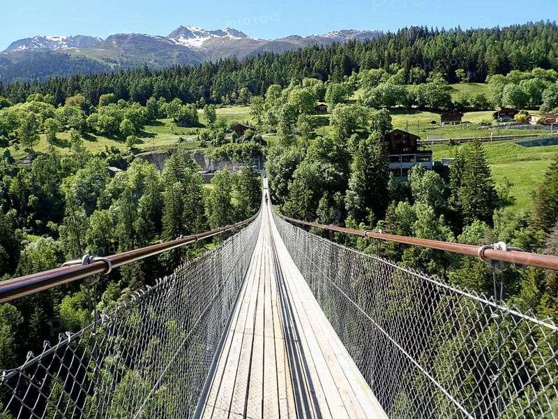 Impressive suspension bridge stretching in the green forest landscape of the Alps, Goms Bridge, Fürgangen, Mühlebach, Goms, Canton of Valais, Switzerland
