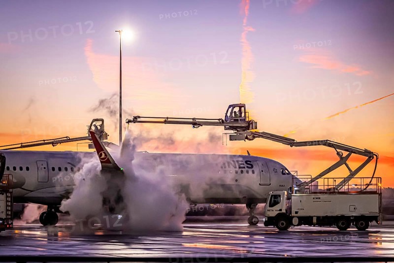 Frost at the airport in front of sunrise. A Turkish Airways aircraft is de-iced. Airbus A321-231. Fraport airport. Frankfurt am Main, Hesse, Germany