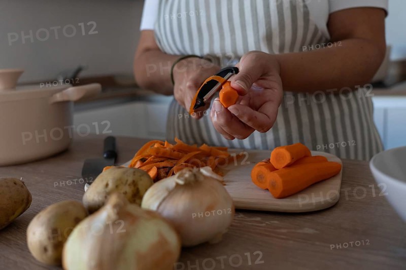 Hands peeling fresh carrot for homemade healthy meal. Clean eating, simple cooking and everyday routine
