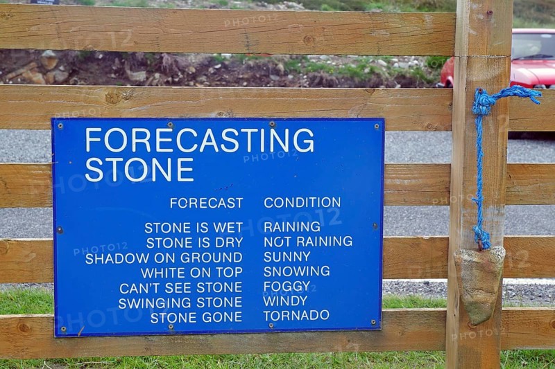 Wooden sign with blue board for humorous weather forecasting by predicting the state of the stone, Outer Hebrides, Hebrides, Scotland, Great Britain