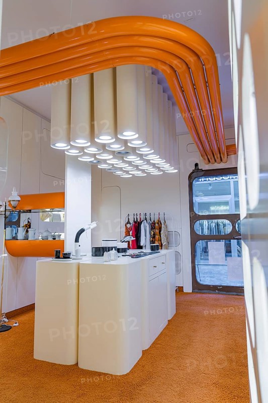 Contemporary kitchen with eye-catching white lighting and orange decoration