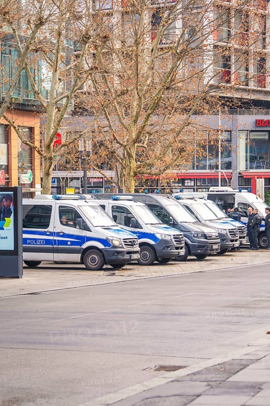 Several police vehicles park in an urban environment, wintry atmosphere