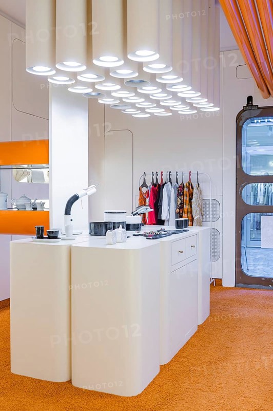 Modern kitchen with futuristic design and eye-catching lighting, orange carpet