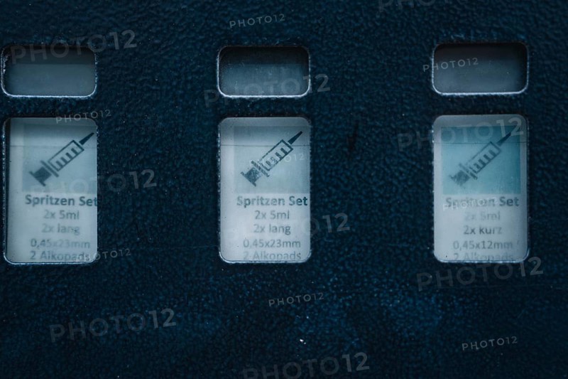 Close-up view of medical syringe sets in blue packaging