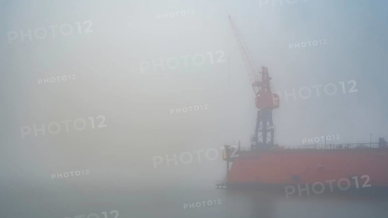 View of a dry dock at the port of America with a crane standing in fog, Cuxhaven, Lower Saxony, Germany