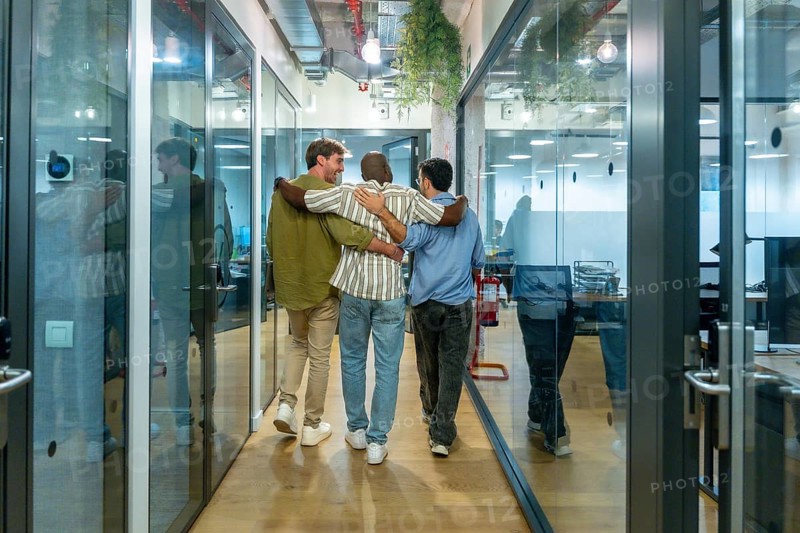 Diverse business colleagues walking together down a modern office corridor, reflecting teamwork, friendship, and a positive work environment during their break
